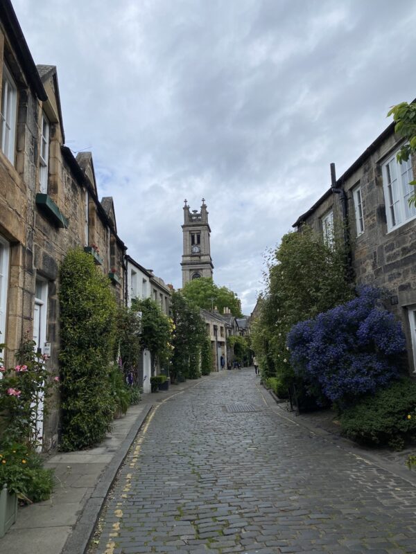 Cobblestone street in Edinburgh's Old Town with historic buildings and shops, a must-visit for solo travel in Edinburgh.